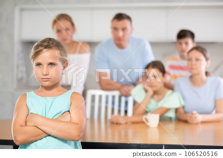 Angry female child turned away from parents and sisters and ignores relatives. Angry female child turned away from parents and sisters and ignores relatives. 106520516