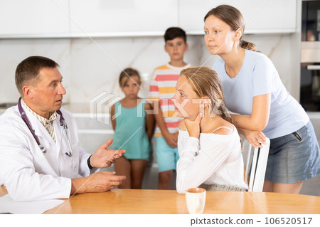 Family physician consults girl child with sore throat from large family at home Family physician consults girl child with sore throat from large family at home 106520517