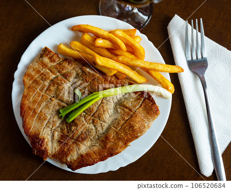 Roasted pork with spring onion and fried potatoes served beautifully on plate Roasted pork with spring onion and fried potatoes served beautifully on plate 106520684