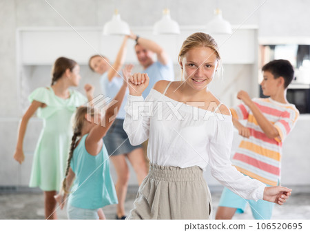 Behind cheerful girl, big family of parents, sisters, brother is rejoicing, dancing, having fun. Behind cheerful girl, big family of parents, sisters, brother is rejoicing, dancing, having fun. 106520695