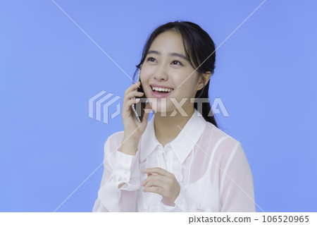 Portrait of a young woman with blue back smartphone Portrait of a young woman with blue back smartphone 106520965