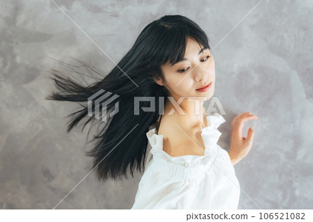 Woman with black hair blowing in the wind Hair care image 106521082