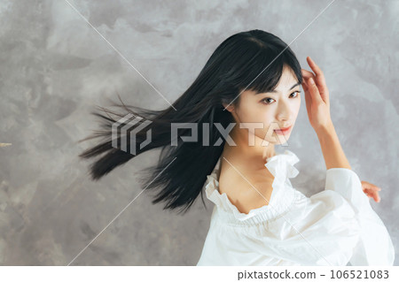 Woman with black hair blowing in the wind Hair care image 106521083