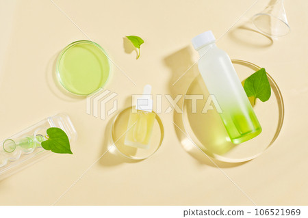 Fish mint leaves decorated with cosmetic container and a glass petri dish of green fluid. Fish mint (Houttuynia cordata) is full of medicinal properties 106521969