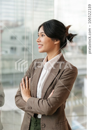 Confident Asian business woman standing and crossing her arms in office 106522189