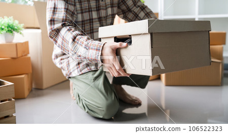 Moving day. close up male asian hand carrying box for move from old to new home or residence 106522323