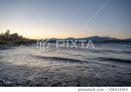 Sunset Autumn season in Abisko with Lake Tornetraesk in background, taken from Bjoerkliden, Swedish Lapland, Sweden 106524403