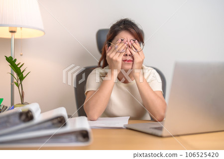 Stressed Asian woman having Tired and Sleepy while working, female businesswoman using laptop with headache at office, Exhausted woman with computer at home late night. Overload and Overworked Stressed Asian woman having Tired and Sleepy while working, female businesswoman using laptop with headache at office, Exhausted woman with computer at home late night. Overload and Overworked 106525420