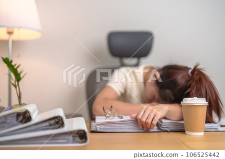 Stressed Asian woman having Tired and Sleepy while working, female businesswoman having headache at office, Exhausted woman with documents folder stack at home late night. Overworked and Overtime Stressed Asian woman having Tired and Sleepy while working, female businesswoman having headache at office, Exhausted woman with documents folder stack at home late night. Overworked and Overtime 106525442