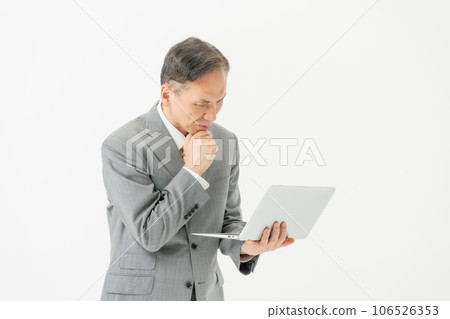 A worried businessman holding a computer A worried businessman holding a computer 106526353