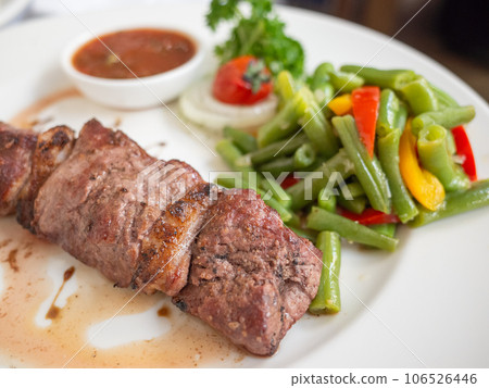 [Ukraine] A plate of skewered meat, green beans, and sauce served at a Tatar restaurant in the capital, Kiv. 106526446