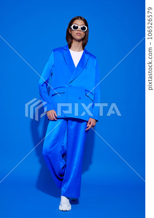 Fashion asian female model in blue suit, white boots and sunglasses. 106526579