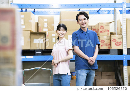 Male and female employees working in a warehouse 106526850