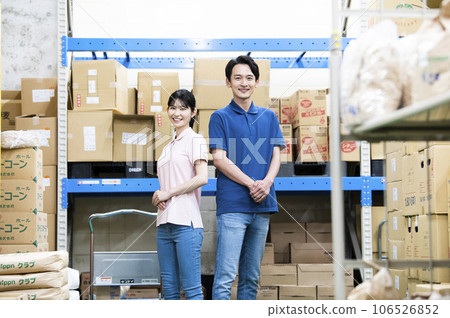Male and female employees working in a warehouse 106526852