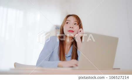 Young asian woman working at home. Happy female using computer laptop on desk at house Young asian woman working at home. Happy female using computer laptop on desk at house 106527214