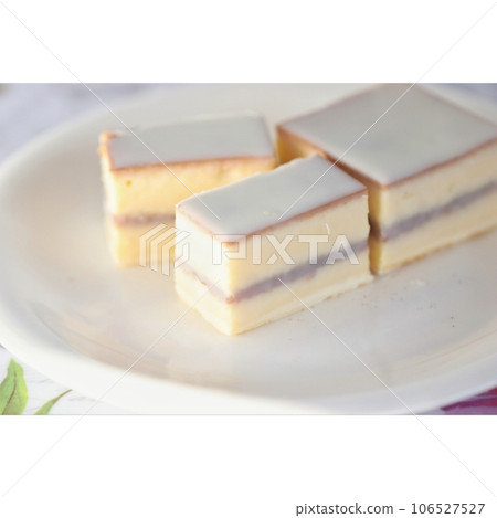 Deluxe cake coated with white chocolate on a white plate 106527527