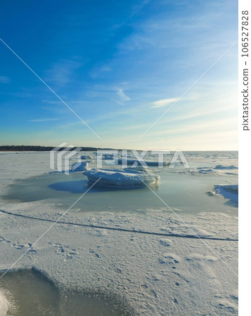 The Baltic Sea The Gulf of Riga in winter. The bay is covered with ice with small pieces of ice. Latvian winter at Ainazu beach. The Baltic Sea The Gulf of Riga in winter. The bay is covered with ice with small pieces of ice. Latvian winter at Ainazu beach. 106527828