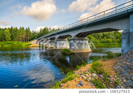 Restored, reconstructed concrete bridge over Latvia's longest river Gauja near the city of Strenci. Bridge over the river, in summer. 106527915