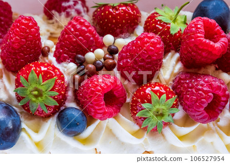 Close up shot of meringue roll Pavlova cake with cream and fresh berries: blueberries, raspberries, strawberries Close up shot of meringue roll Pavlova cake with cream and fresh berries: blueberries, raspberries, strawberries 106527954