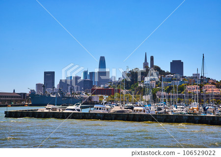 View of San Francisco downtown skyscrapers and Coit Tower from bay with boats docked at pier 106529022
