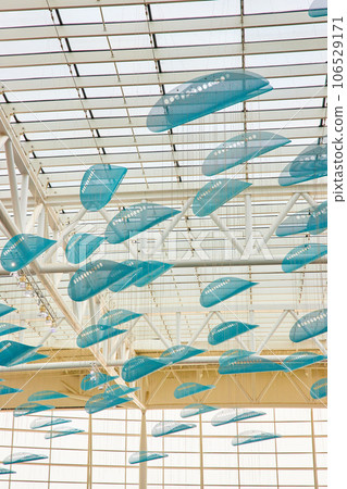 White ceiling with hanging blue abstract art in curved shells White ceiling with hanging blue abstract art in curved shells 106529171