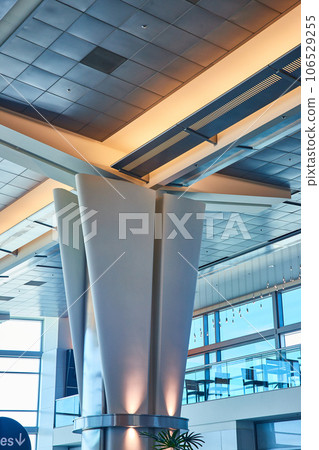 Gorgeous blue and yellow lighting on pillar architecture inside airport with balcony and seats 106529255