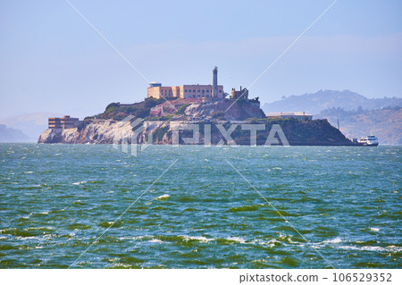Choppy San Francisco Bay waters with full view of Alcatraz Island and docked boat 106529352