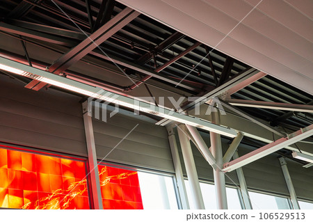 Abstract view of ceiling at an airport with vibrant red and orange flame window art Abstract view of ceiling at an airport with vibrant red and orange flame window art 106529513