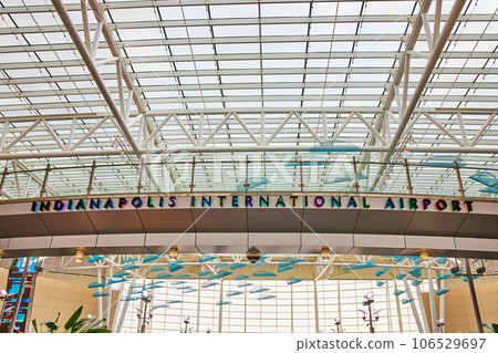Indianapolis International Airport bridge multicolored lights behind sign with hanging blue art 106529697