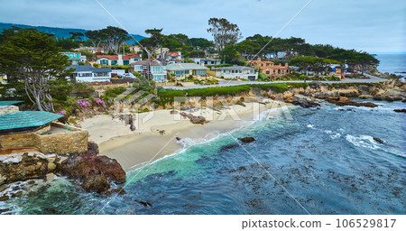 Aerial with edge of Clinton Walker House by Frank Lloyd Wright and Carmel Beach with houses 106529817