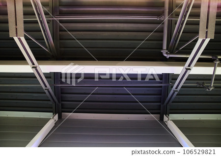Abstract view of grayscale ceiling with different pillars and beams with a pipe Abstract view of grayscale ceiling with different pillars and beams with a pipe 106529821