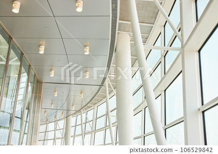 Abstract view of white ceiling architecture and pillars with windows leading to blown out sky Abstract view of white ceiling architecture and pillars with windows leading to blown out sky 106529842