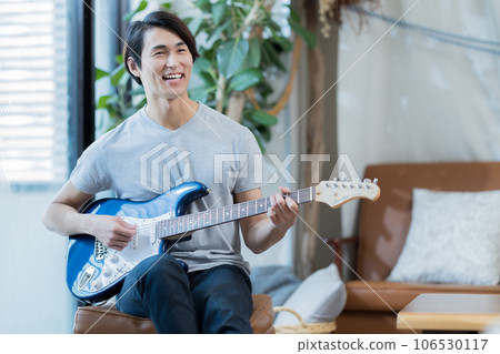 在家練習吉他的年輕人 106530117