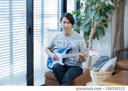在家練習吉他的年輕人 106530122