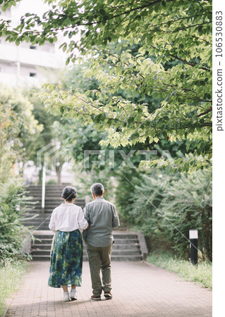 Rear view of a smiling senior couple cuddling 106530883