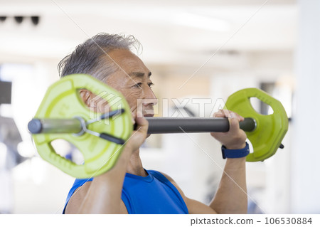 Middle-aged man doing shoulder press at the fitness gym 106530884