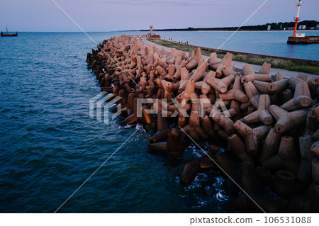 Waves break on concrete tetrapod breakwaters at sea coast. Protection from large waves. Baltic Sea coast at Wladyslavovo port at sunset Waves break on concrete tetrapod breakwaters at sea coast. Protection from large waves. Baltic Sea coast at Wladyslavovo port at sunset 106531088