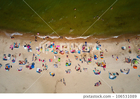 Aerial view of sea landscape with crowded sand beach in Wladyslawowo. Baltic sea coastline with swimming people in Poland. Resort town in summer season 106531089