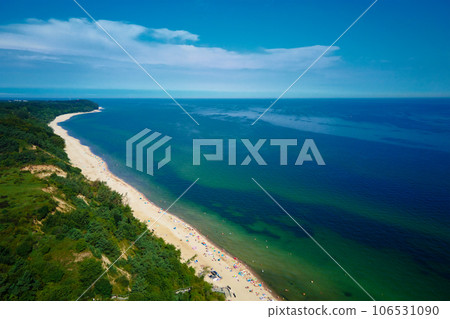 Aerial view of sea landscape with crowded sand beach in Wladyslawowo. Baltic sea coastline with swimming people in Poland. Resort town in summer season 106531090