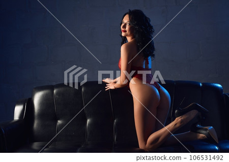 Passion of sexy woman in red underwear sitting on leather sofa 106531492