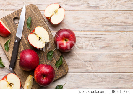 Fresh red apples with green leaves on table. cutting board with knife. Top view Fresh red apples with green leaves on table. cutting board with knife. Top view 106531754