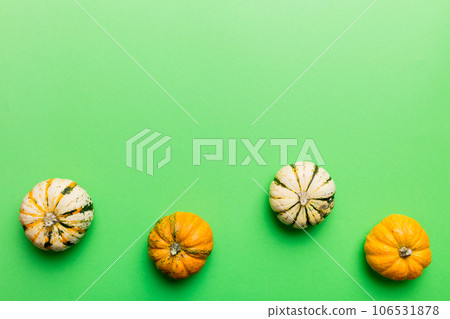 Autumn composition of little orange pumpkins on colored table background. Fall, Halloween and Thanksgiving concept. Autumn flat lay photography. Top view vith copy space 106531878