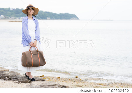 Refreshing woman standing on the beach 106532420