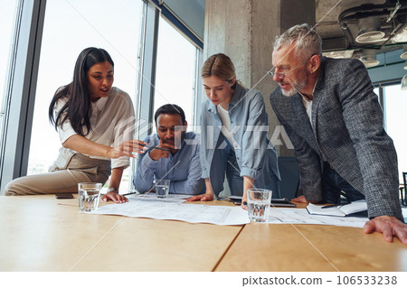 Team of business investors is discussing a new project in modern office. Concept of financing Team of business investors is discussing a new project in modern office. Concept of financing 106533238