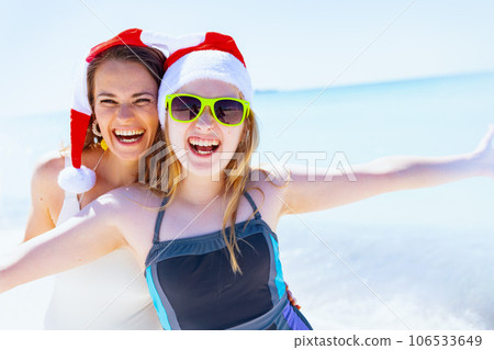 smiling mother and teenage daughter at beach having fun time 106533649