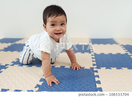 happy infant baby crawling on mat or jigsaw floor happy infant baby crawling on mat or jigsaw floor 106533704