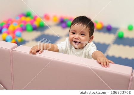 happy infant baby standing in fence of playpen happy infant baby standing in fence of playpen 106533708