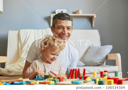Fun activities for young children. Building blocks of learning. Child's playful journey of discovery. happy cheerful father playing educational toys with his daughter at home interior Fun activities for young children. Building blocks of learning. Child's playful journey of discovery. happy cheerful father playing educational toys with his daughter at home interior 106534304