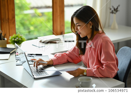 Beautiful businesswoman answering negotiations email on laptop or planning work at desk 106534971