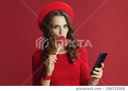 woman on background with heart shaped candy using phone woman on background with heart shaped candy using phone 106535088